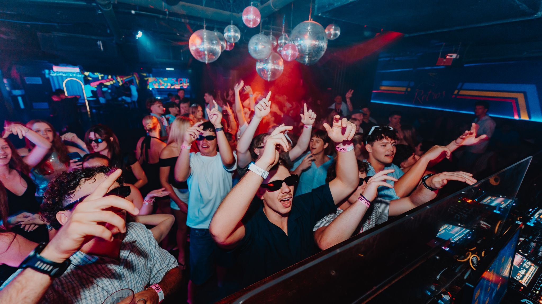 DJ at decks with crowd reaction, Retros Gold Coast